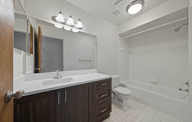 A bathroom with a white sink and a white bathtub.