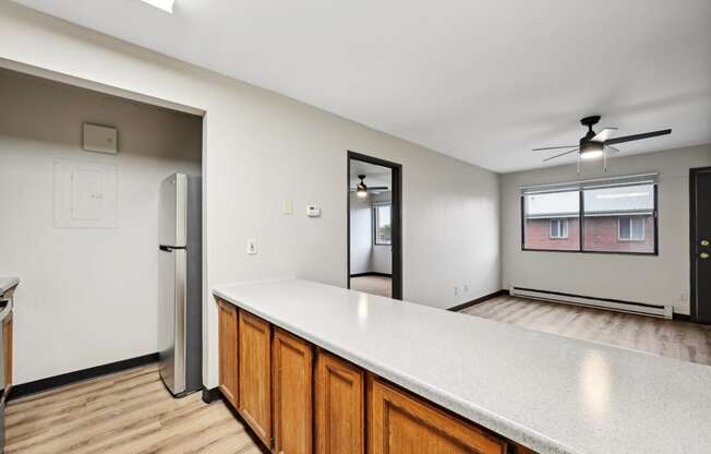 the kitchen and living room of an empty house with a refrigerator