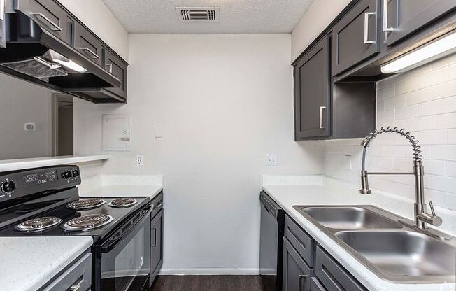 a kitchen with a stove top oven next to a sink at Sunset Canyon, San Antonio, Texas