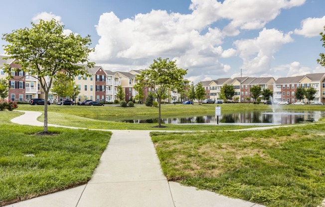 a park with a pond in front of an apartment building