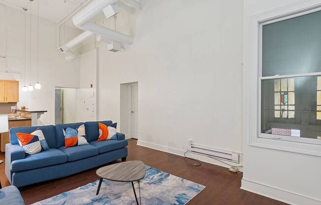 A living room with a blue couch and a small table.