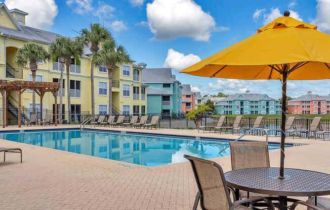 tables and umbrellas with seating at Bermuda Estates Apartments in Ormond Beach, FL