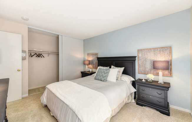 Master bedroom in the model home. Queen size bed with two nightstands. Large closet and carpeting on the floors.