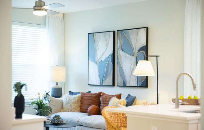 a living room with a couch and two paintings on the wall