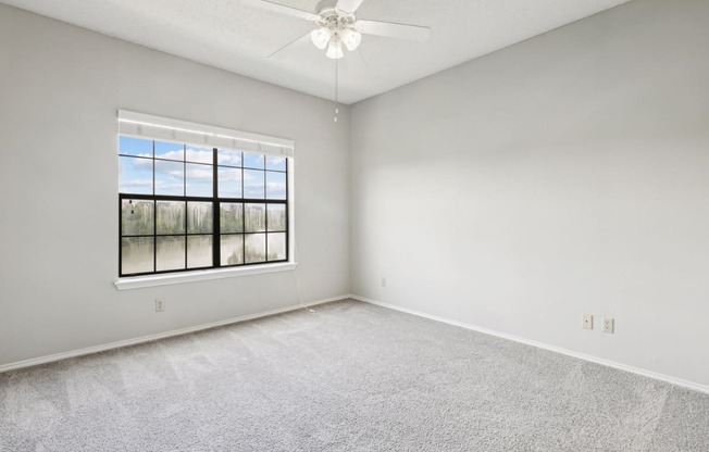 Bedroom 1 in the B1 floor plan with window and a ceiling fan at Jefferson Creek Apartments in Irving, TX.