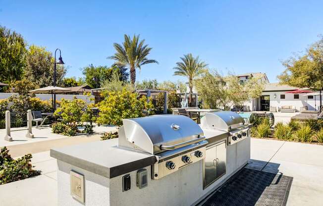A silver outdoor kitchen with a grill and sink.