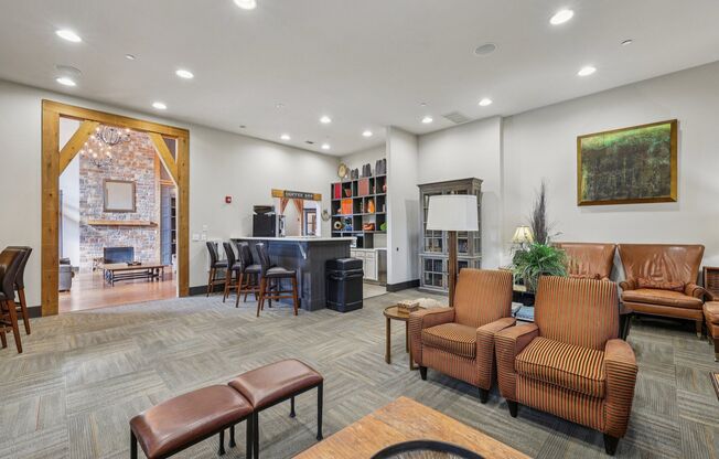 A living room with brown furniture and a painting on the wall.
