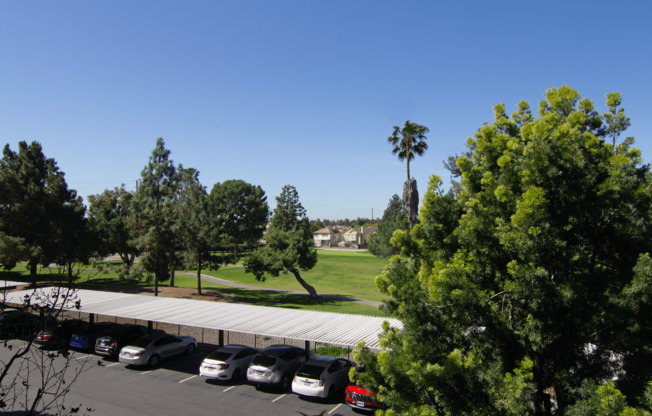 A parking lot with cars and trees.