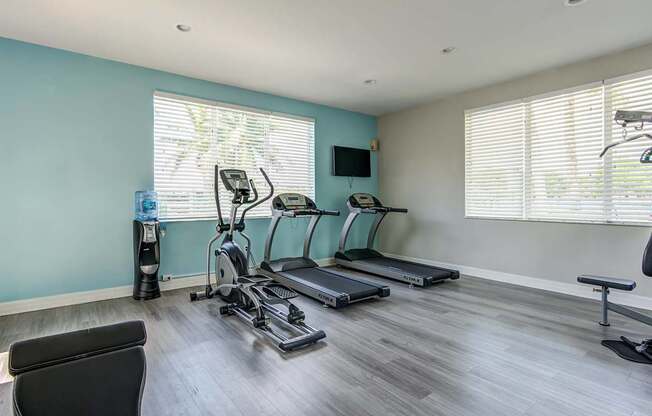 A room with a treadmill, elliptical trainer, and a stationary bike.