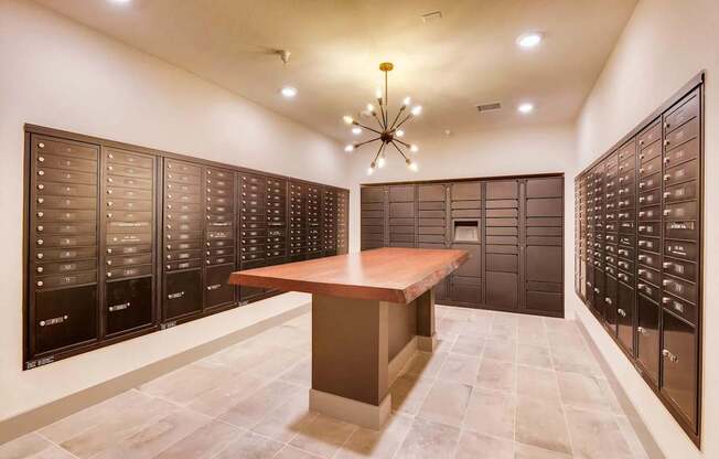 A room with a table and a chandelier with a wall of lockers on either side.