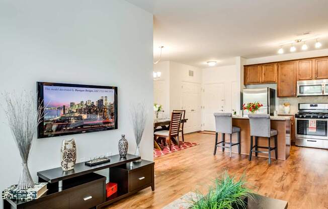 A modern kitchen with wooden floors and a large painting on the wall.