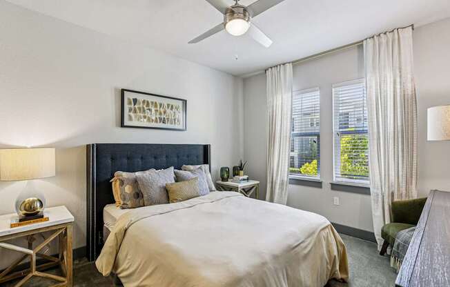 A bedroom with a large bed and a ceiling fan.