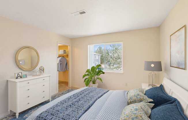 a bedroom with a bed and a dresser and a window
