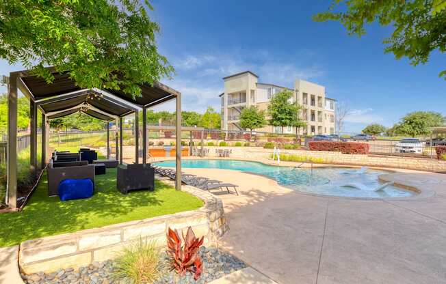 a swimming pool with a pavilion and a building in the background