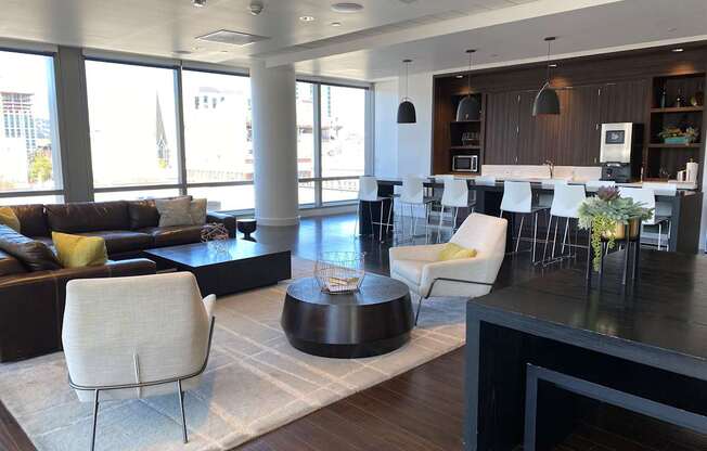 A modern living room with a black coffee table and white chairs.