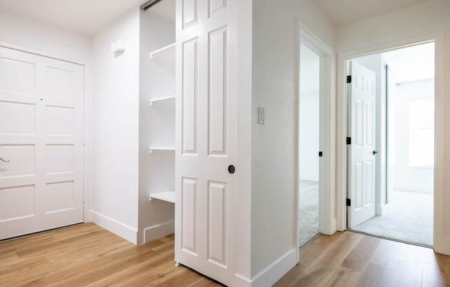 A white door with a shelf underneath it.