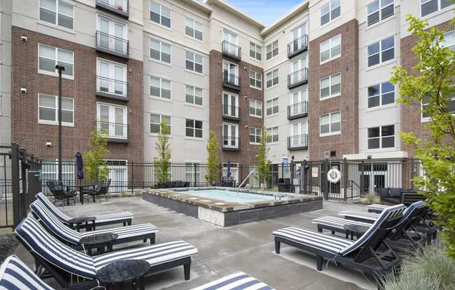 a courtyard with a hot tub and lounge chairs at the bradley braddock road station at 200 City View, Provo, Utah
