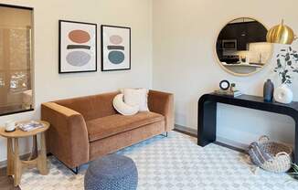 a cozy living room with a modern velvet couch and other contemporary furniture in the guest suite, available for resident use