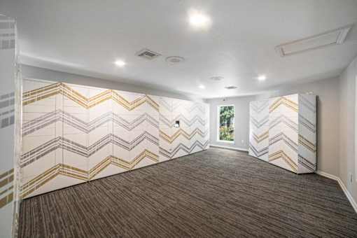 A room with a chevron patterned wallpaper and carpet.