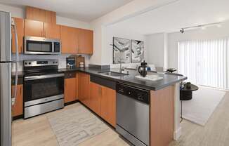 A modern kitchen with wooden cabinets and stainless steel appliances.