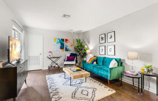 A living room with a green couch and a rug.