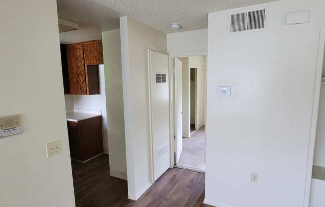 Front room view of kitchen and hallway to bedrooms in unit at Magnolia Apartments in Riverside, California.