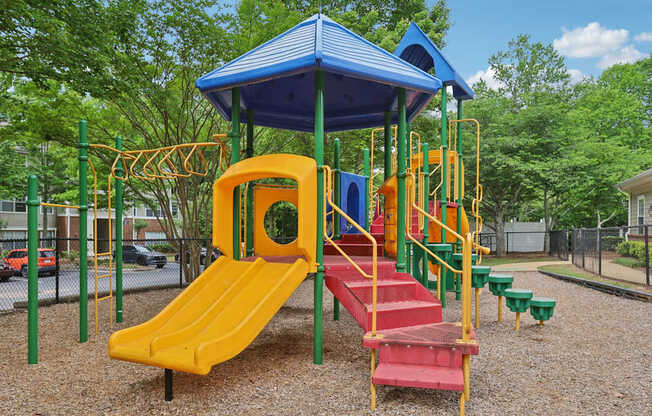 A playground with a yellow slide and a blue roof.