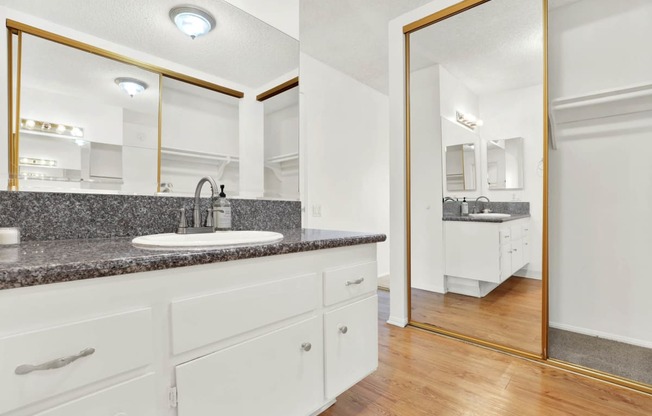 a bathroom with a sink and a mirror at Casa Del Amo Apartments, Torrance, CA