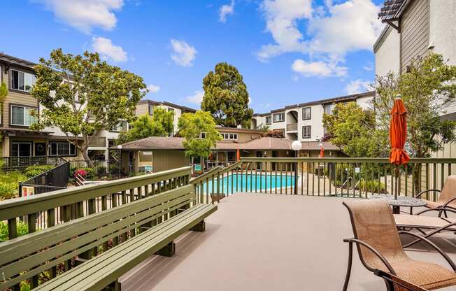 a patio with a pool and chairs and buildings