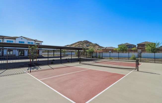 a tennis court with a house and a mountain in the background at Stella, San Tan Valley, AZ