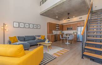A living room with a yellow sofa and a grey couch.