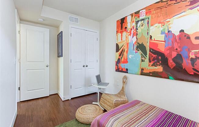 small bedroom with bed, dresser, desk and window at fairway park apartments in washington dc