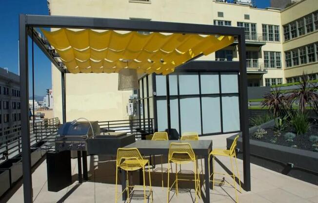 a pergola with yellow chairs on a patio