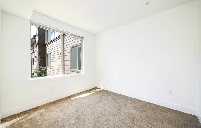 a living room with a large window and a carpet