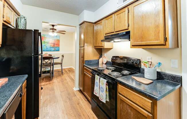 a kitchen with wood cabinets and black appliances