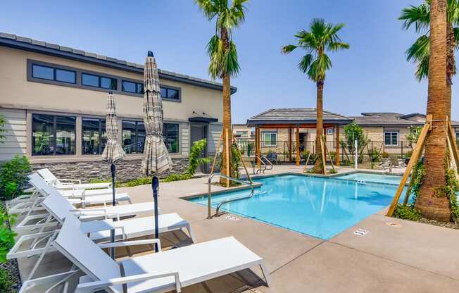 our apartments have a swimming pool with chairs and palm trees at Grandstone at Sunrise, Peoria, 85383