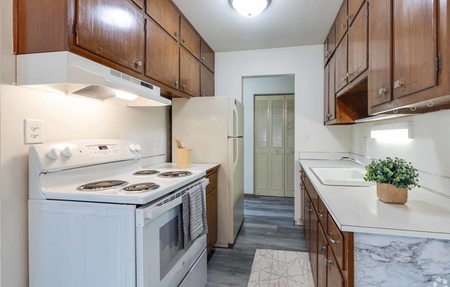 a kitchen with white appliances and wooden cabinets