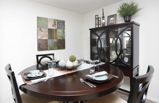 dining room with 4 person circular dining table and dishware credenza