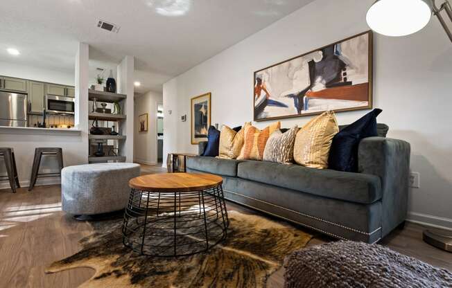 a living room with a gray couch and a round coffee table