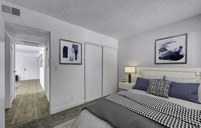A bedroom with a large bed and two framed pictures on the wall.