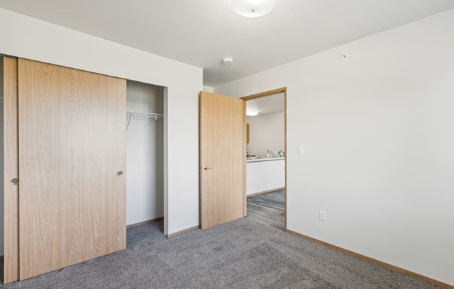 a bedroom with a door to a closet and a bathroom