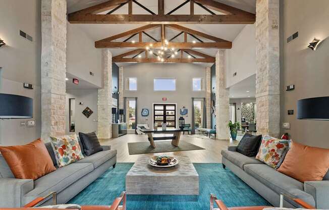 A large, open living room with a stone pillar and a grey couch.