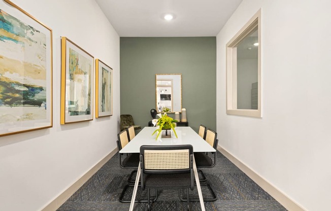 a dining room with a table and chairs and paintings on the wall