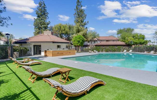 A house with a pool and sun loungers.