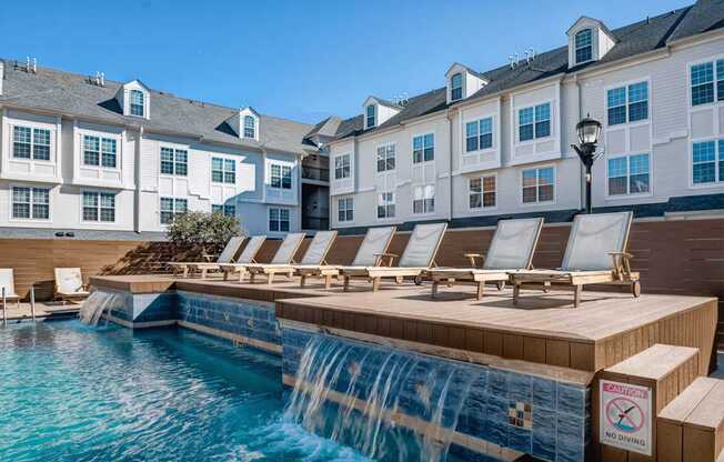 a pool with a waterfall and a row of lounge chairs at Harbor Pointe at Harbor Pointe, Bayonne, NJ, 07002