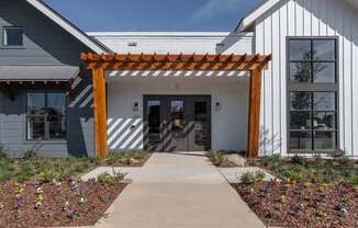 a covered walkway in front of a white building with a wooden structure