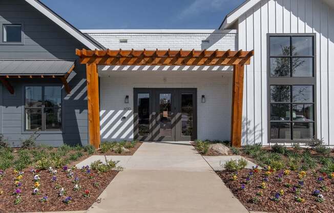 a covered walkway in front of a white building with a wooden structure