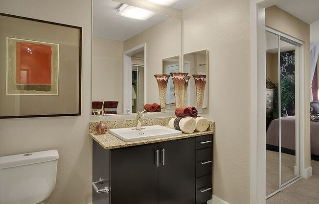 a bathroom with a toilet sink and mirror