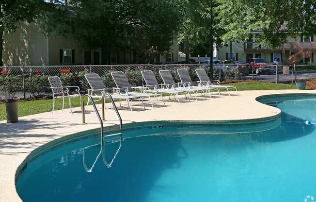 a pool with a bunch of lounge chairs around it