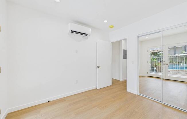 A room with a sliding glass door leading to a balcony.